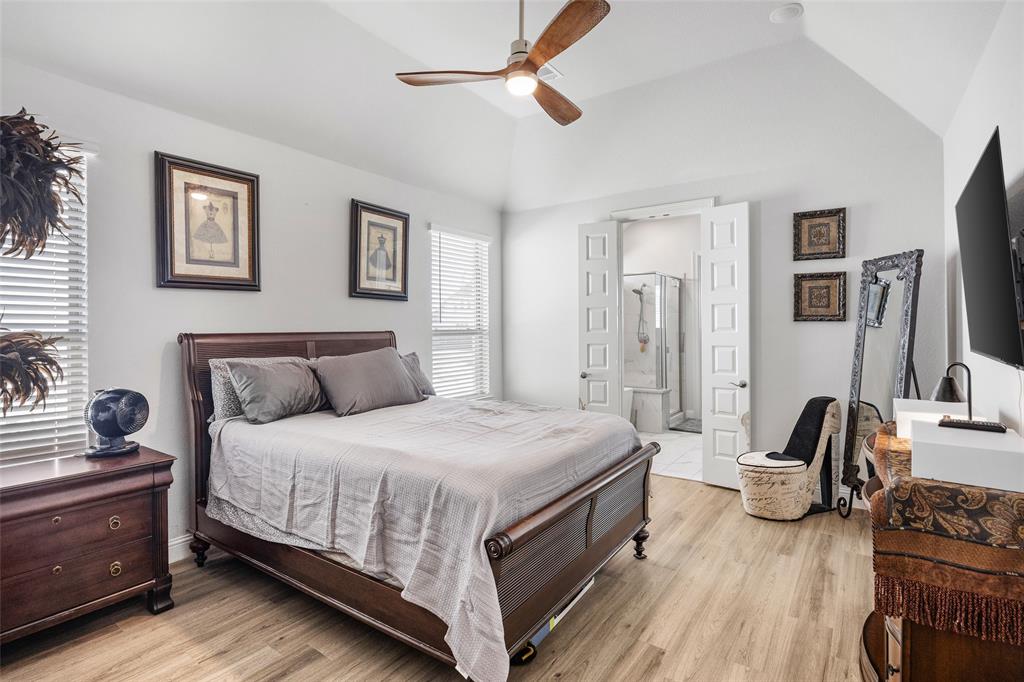 2628 Flycatcher Road Fort Worth, TX 76118 - Photo 16 of 38 Bedroom featuring lofted ceiling, light wood-type flooring, ceiling fan, and ensuite bath