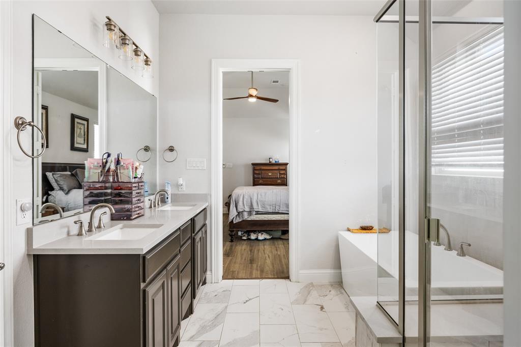 2628 Flycatcher Road Fort Worth, TX 76118 - Photo 21 of 38 Bathroom with connected bathroom, a freestanding bath, double vanity, light marble finish floors, and a ceiling fan