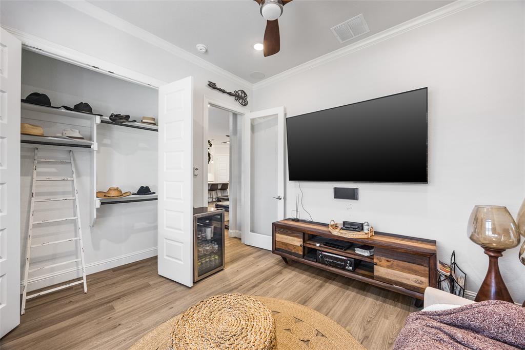 2628 Flycatcher Road Fort Worth, TX 76118 - Photo 25 of 38 Bedroom with ornamental molding, light wood-type flooring, wine cooler, a ceiling fan, and a closet