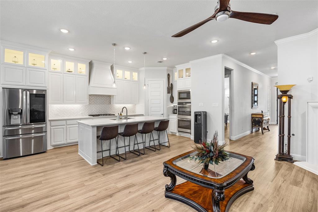 2628 Flycatcher Road Fort Worth, TX 76118 - Photo 9 of 38 Kitchen featuring decorative backsplash, stainless steel appliances, a breakfast bar area, white cabinets, and recessed lighting