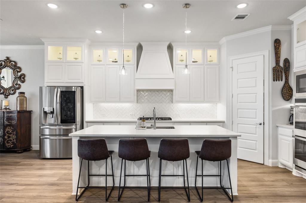 2628 Flycatcher Road Fort Worth, TX 76118 - Photo 10 of 38 Kitchen with crown molding, stainless steel appliances, decorative light fixtures, a breakfast bar, and a center island with sink