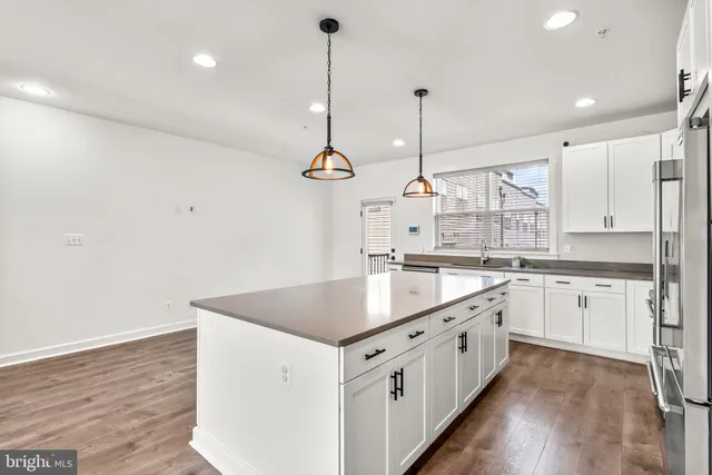 a kitchen with granite countertop a sink a counter space appliances and cabinets