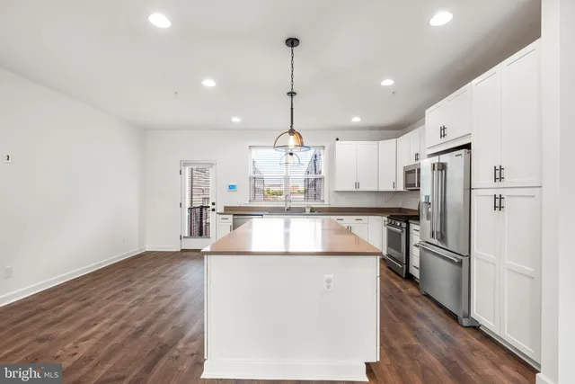 a kitchen with kitchen island a counter top space stainless steel appliances and cabinets