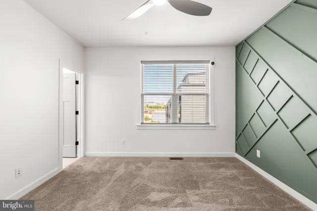 a view of an empty room with window and cabinet