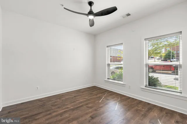 a view of an empty room with wooden floor
