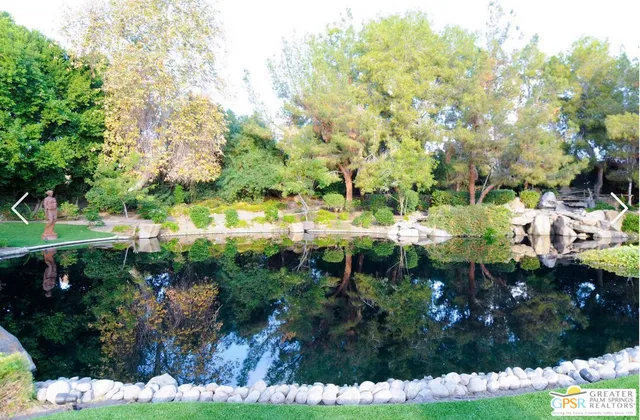 a view of a house with a yard and palm trees