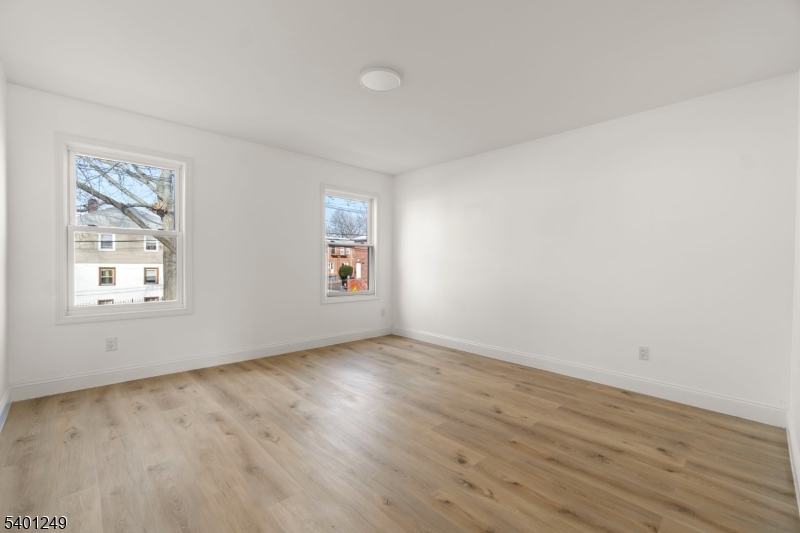 390 Clinton Place Newark, NJ 07112 - Photo 13 of 17 an empty room with wooden floor and windows