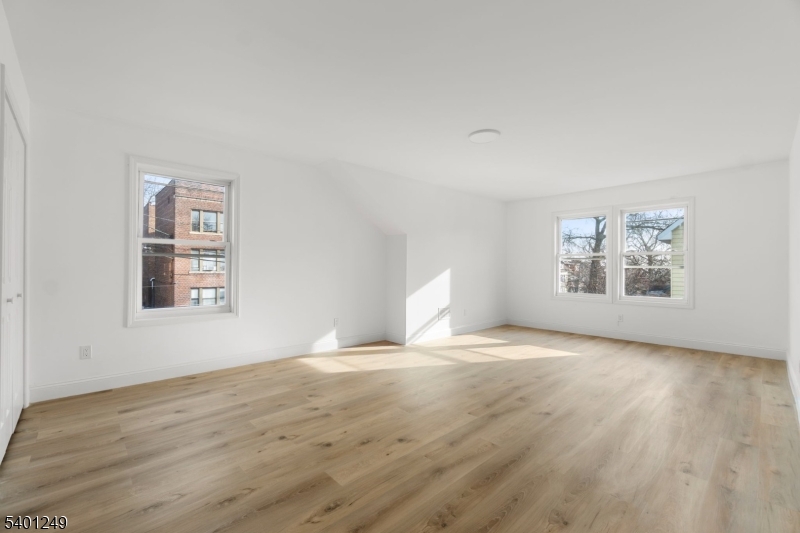 390 Clinton Place Newark, NJ 07112 - Photo 14 of 17 a view of an empty room with a window and wooden floor