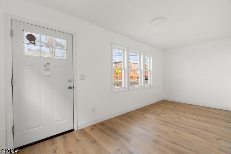 390 Clinton Place Newark, NJ 07112 - Photo 2 of 17 an empty room with wooden floor and windows