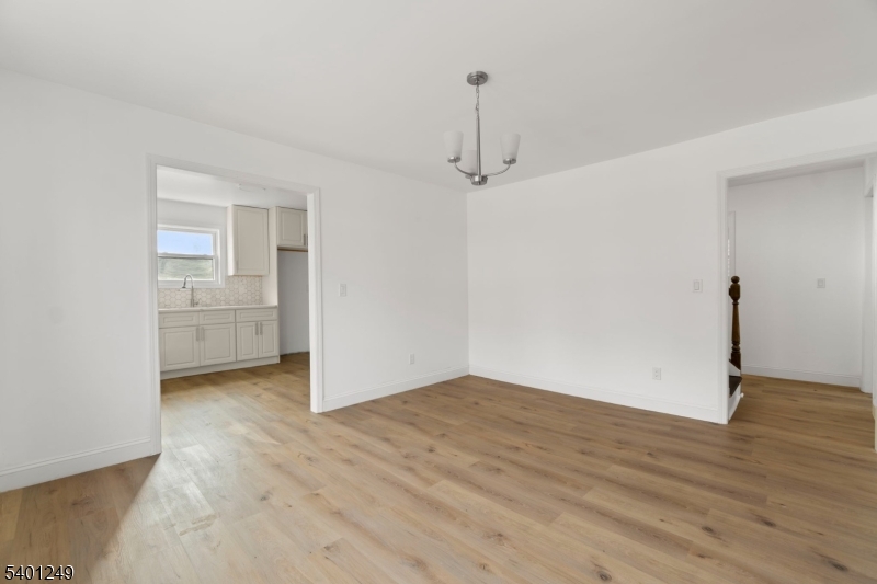 390 Clinton Place Newark, NJ 07112 - Photo 4 of 17 an empty room with wooden floor and windows