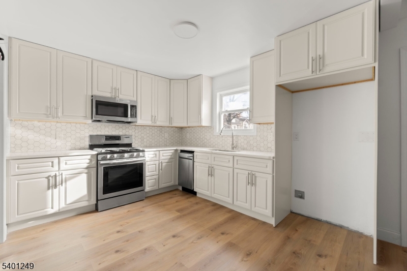 390 Clinton Place Newark, NJ 07112 - Photo 6 of 17 a kitchen with granite countertop white cabinets and stainless steel appliances