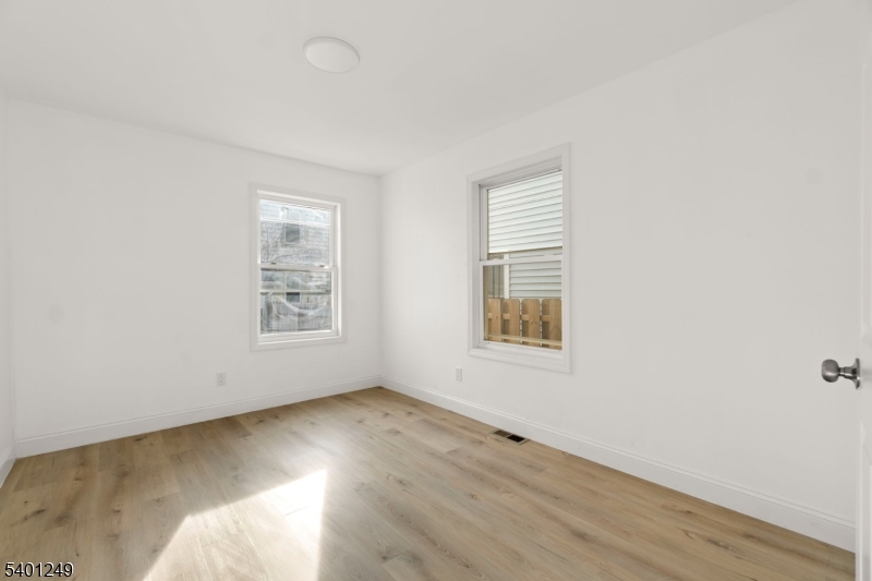 390 Clinton Place Newark, NJ 07112 - Photo 10 of 17 an empty room with wooden floor and windows