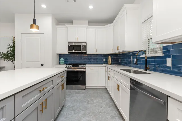 a kitchen with stainless steel appliances and white cabinets