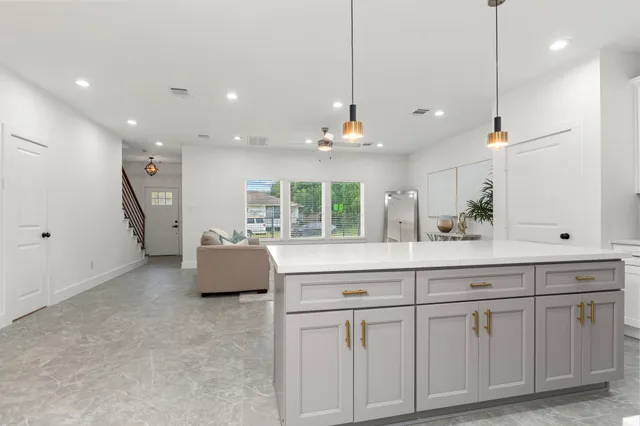 a kitchen with white cabinets and sink