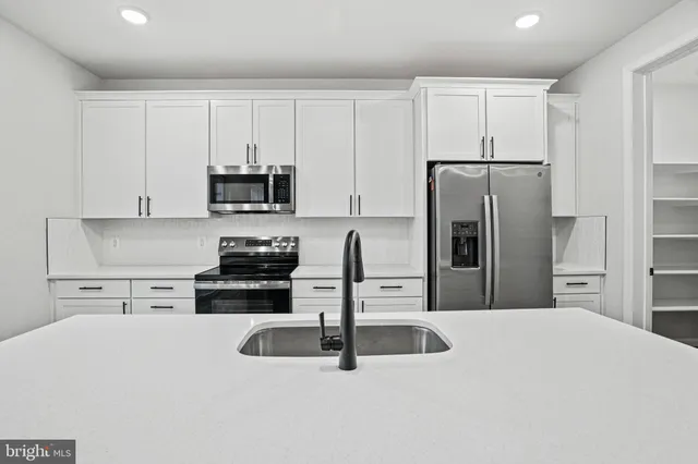 a kitchen with stainless steel appliances a refrigerator sink and cabinets