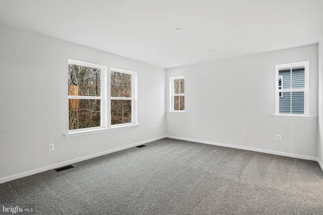 an empty room with a window and a bathroom