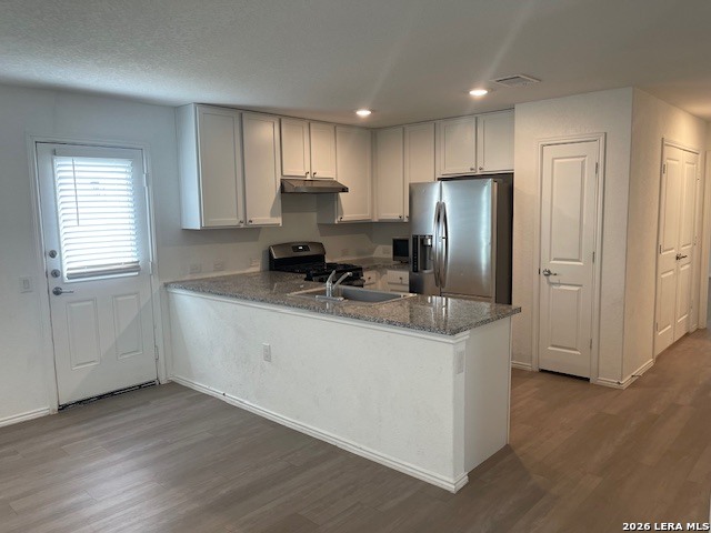 918 Cook Bend San Antonio, TX 78221 - Photo 2 of 21 a kitchen with stainless steel appliances granite countertop a refrigerator a sink a stove a microwave and white cabinets with wooden floor