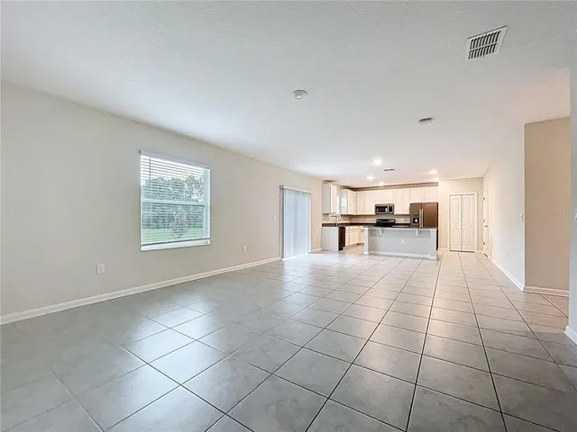 a kitchen with granite countertop a refrigerator and white cabinets