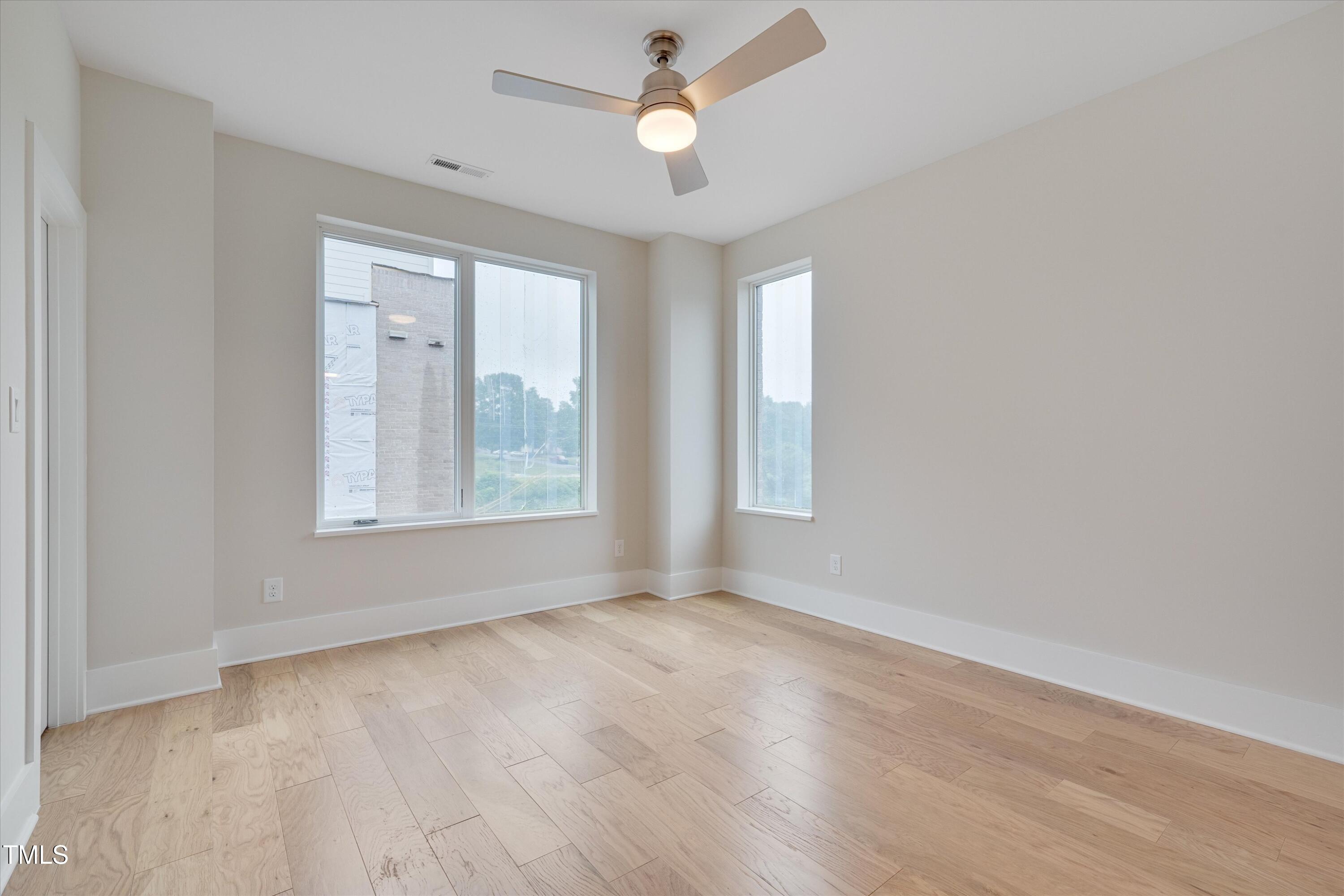 779 Willard Street Durham, NC 27701 - Photo 16 of 32 an empty room with wooden floor ceiling fan and windows