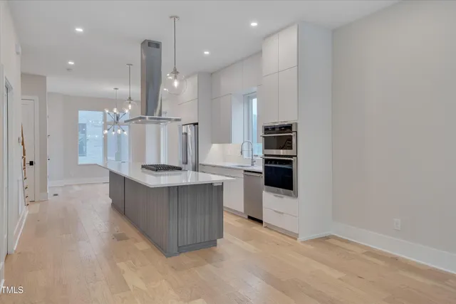a kitchen with stainless steel appliances kitchen island wooden cabinets and a fireplace