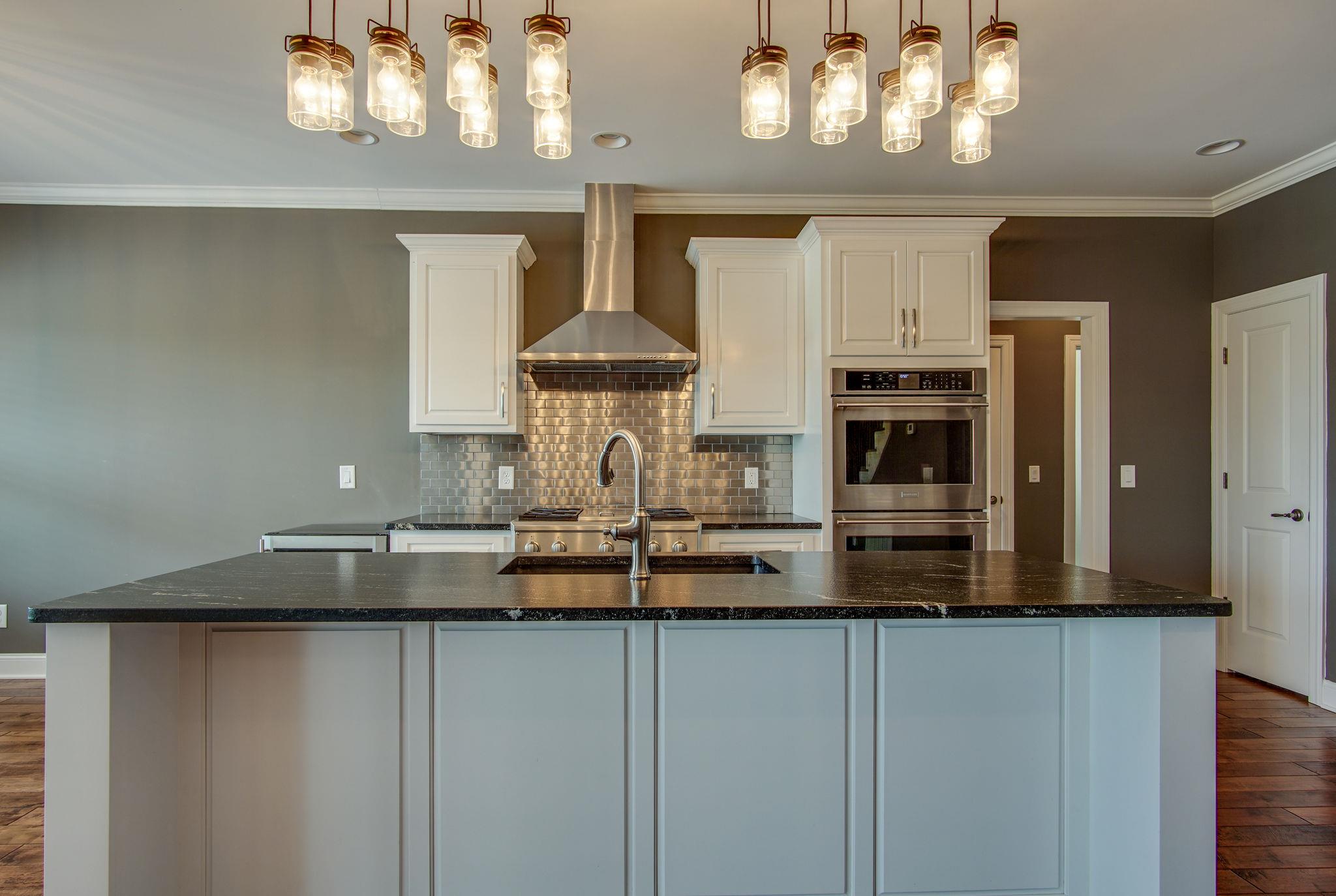 3029 Briley Path Columbia, TN 38401 - Photo 11 of 28 a kitchen with kitchen island granite countertop a sink a stove and cabinets