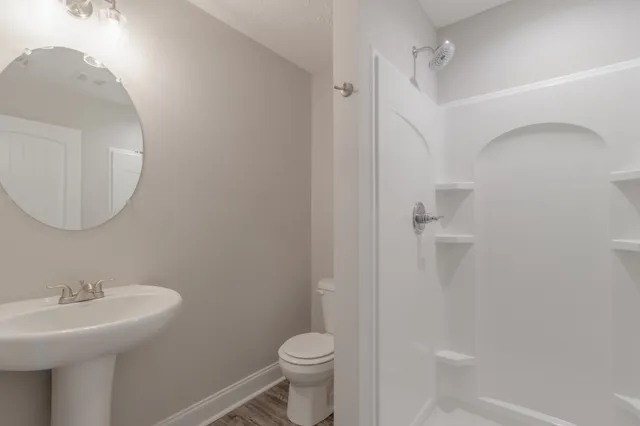 a bathroom with a sink toilet and a mirror