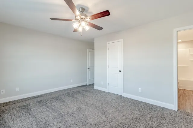 an empty room with chandelier fan
