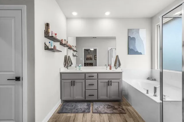 a spacious bathroom with a tub sink and mirror