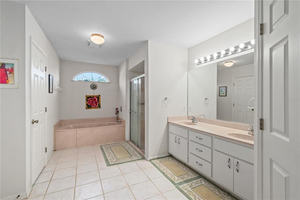 67 Lake Diamond Boulevard Ocala, FL 34472 - Photo 16 of 32 a spacious bathroom with a double vanity sink a mirror and a bathtub