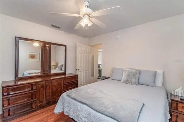 a bedroom with a bed and a large mirror on the dresser