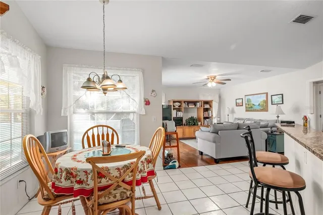 a view of a dining room with furniture a chandelier and wooden floor