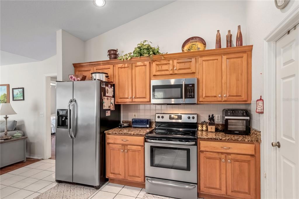 67 Lake Diamond Boulevard Ocala, FL 34472 - Photo 9 of 32 a kitchen with stainless steel appliances granite countertop a refrigerator a stove and a sink