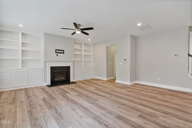 a view of empty room with wooden floor and fireplace