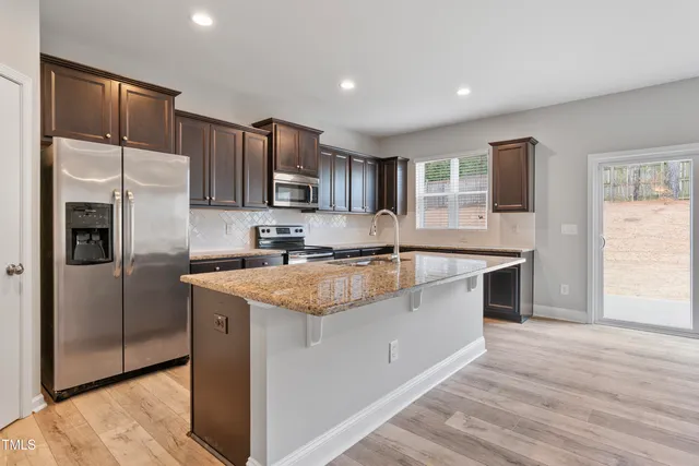 a kitchen with stainless steel appliances granite countertop a stove and a microwave