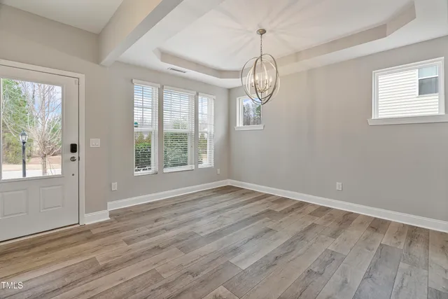 a view of empty room with wooden floor and window