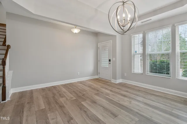 a view of empty room with window and fan
