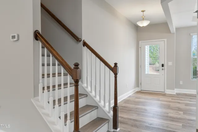 a view of staircase with wooden floor and fan