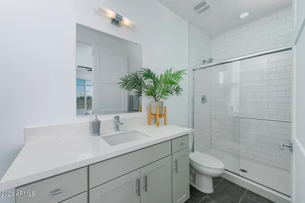 a bathroom with a sink a toilet and shower