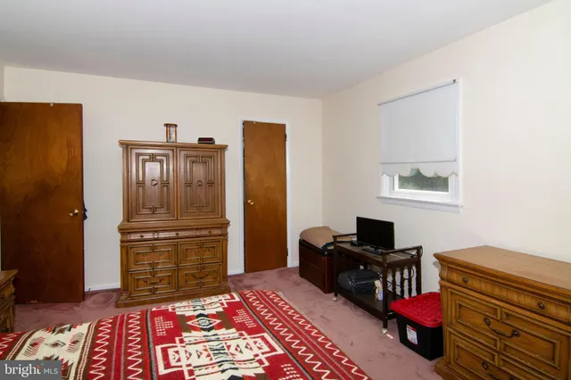 a bedroom with a bed chair and a desk in it