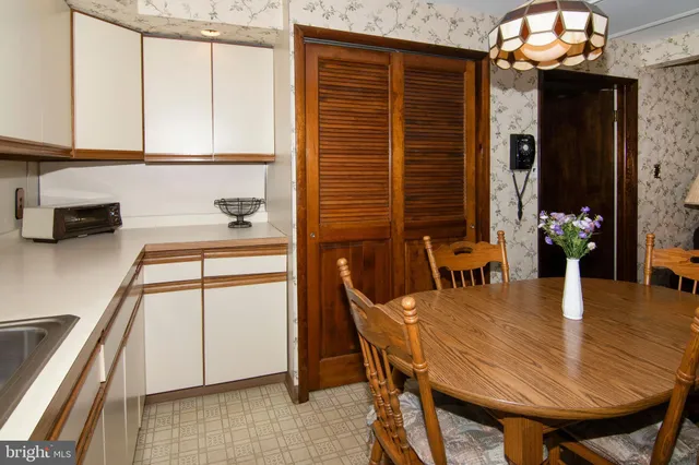 a kitchen with stainless steel appliances granite countertop a stove a refrigerator a dining table and chairs with wooden floor