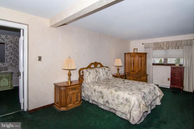 a bedroom with a bed and a flat tv screen on dresser