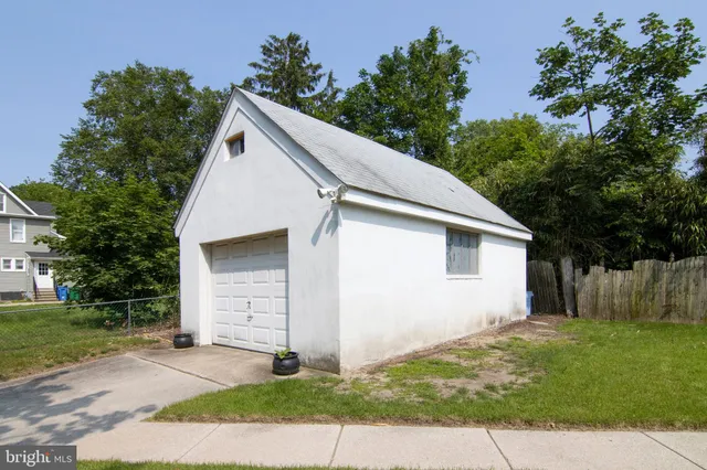 a view of a house with a yard and large trees