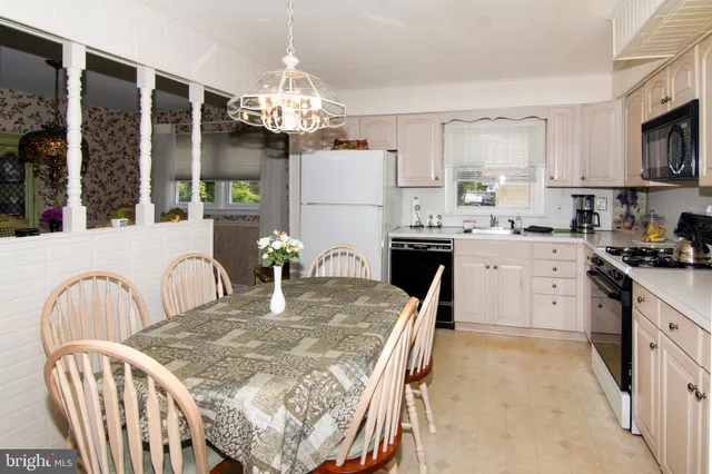 a kitchen with granite countertop a stove a sink a dining table and chairs