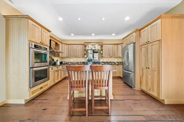 a kitchen with stainless steel appliances kitchen island granite countertop a refrigerator and microwave