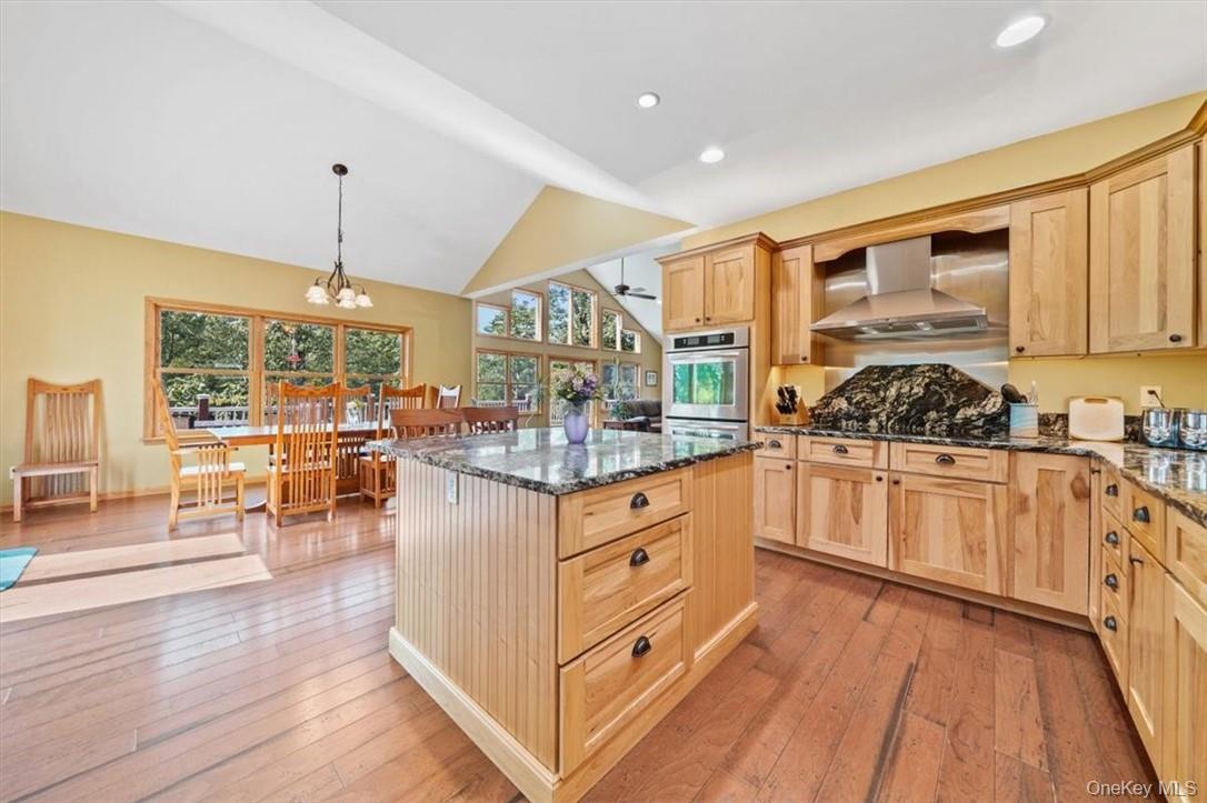 1038 Milanville Road Beach Lake, PA 18405 - Photo 12 of 36 a kitchen with stainless steel appliances kitchen island granite countertop a stove a sink and white cabinets with wooden floor