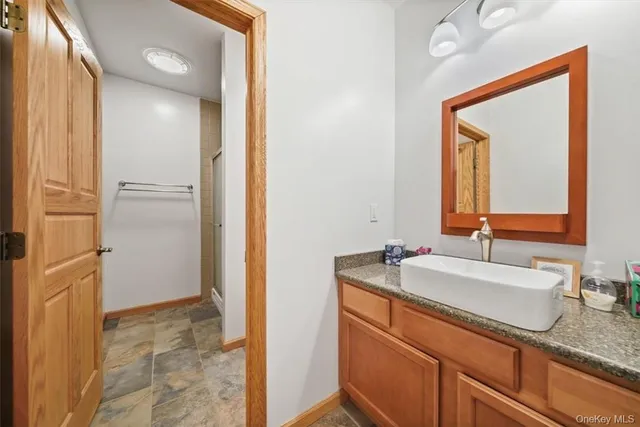 a bathroom with a granite countertop sink and a mirror
