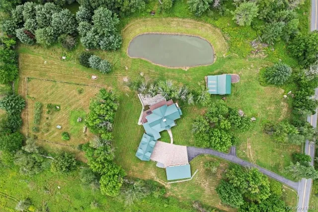 an aerial view of residential house with outdoor space and trees all around