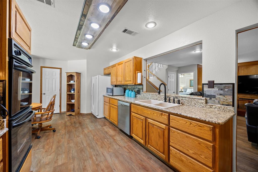 881 Wild Road Van Alstyne, TX 75495 - Photo 14 of 40 a large kitchen with a lot of counter space and a wooden floor