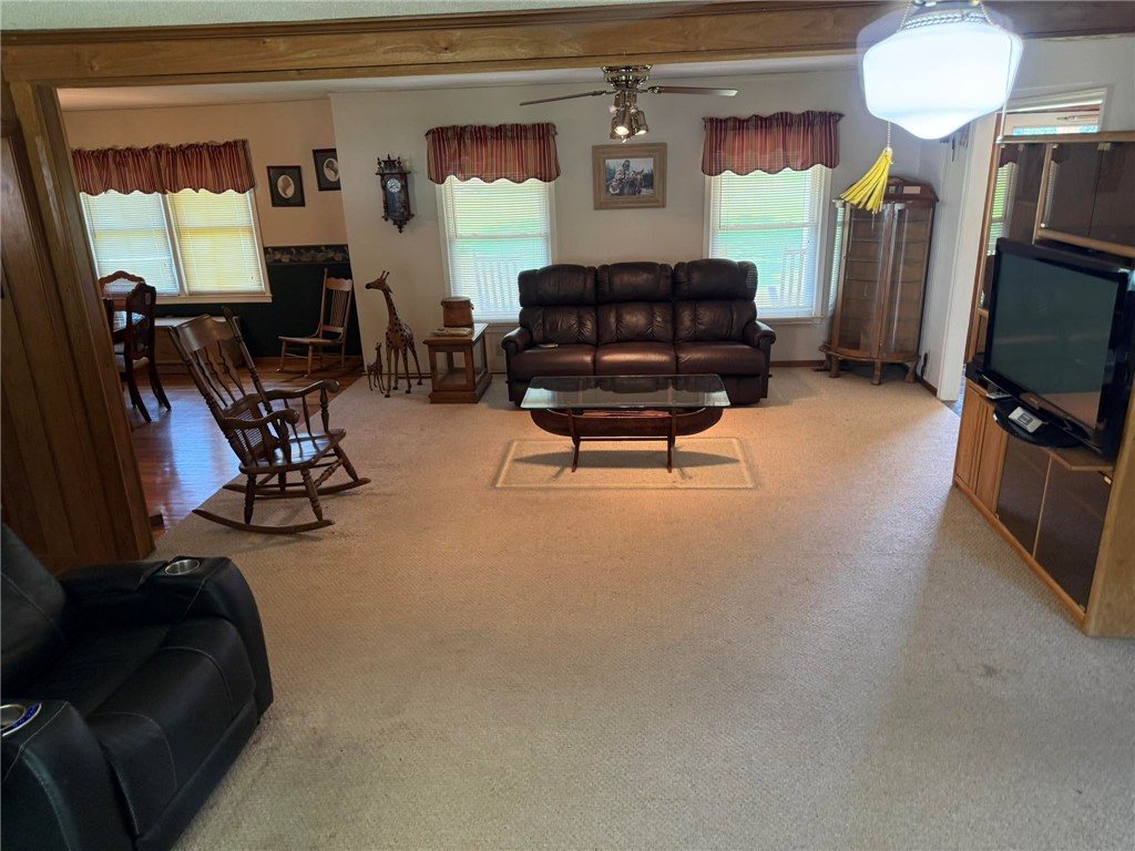 4027 Belhaven Road Belton, SC 29627 - Photo 18 of 24 A comfortable living area with carpeted floors seamlessly connects to a dining space with hardwood floors.
