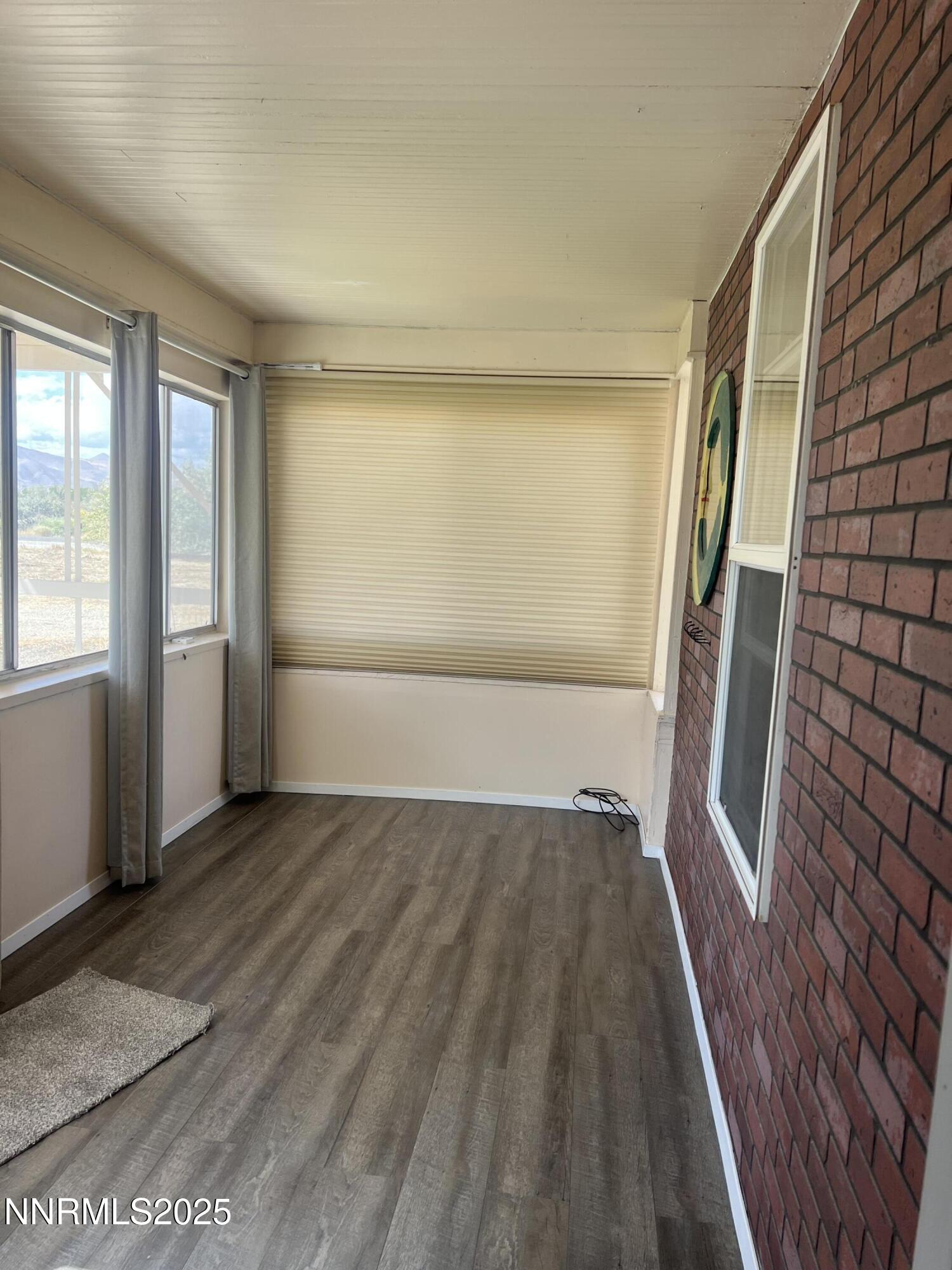 16 Tucker Lane Yerington, NV 89447 - Photo 2 of 12 an empty room with wooden floor and windows